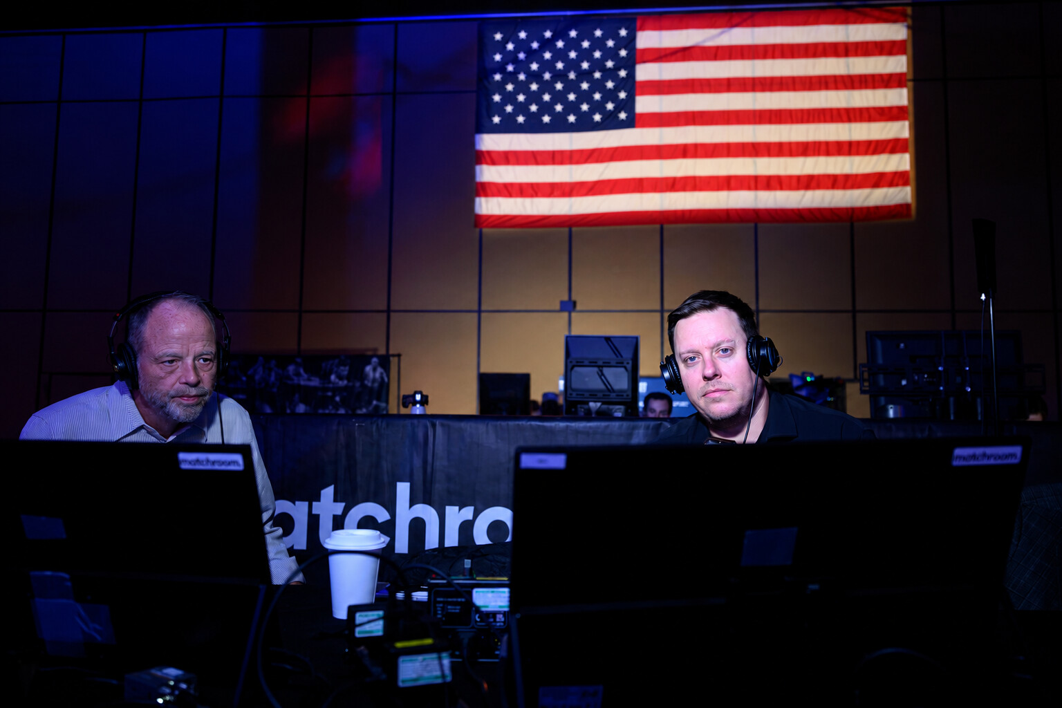 Karl Boyes and a fellow commentator wearing headphones in the pool commentary box